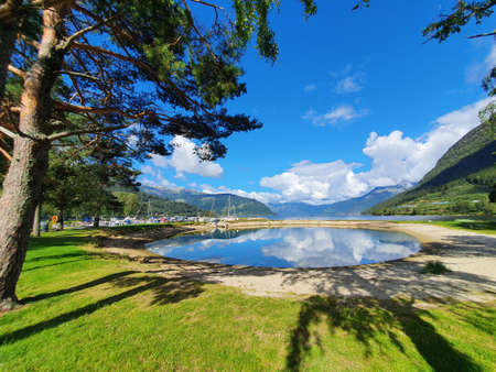 Reflection of the sky and mountains in the blue water - Kinsarvik