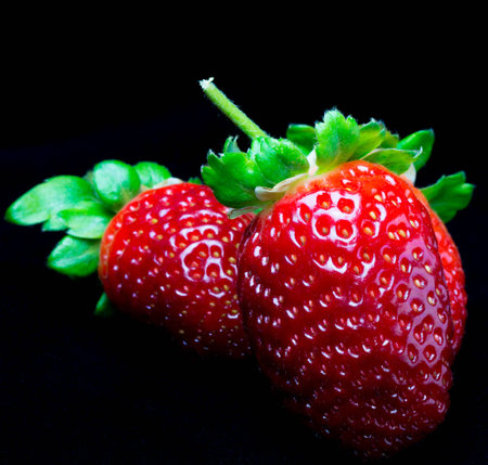 close-up of three fresh strawberries on a black backgroundの写真素材