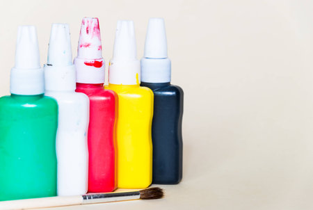 Old and used watercolors containers isolated on a beige background. Concept of spare to buy new onesの写真素材