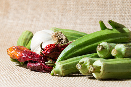 ingredients for stewed okra recipe on a brown cloth backgroundの写真素材