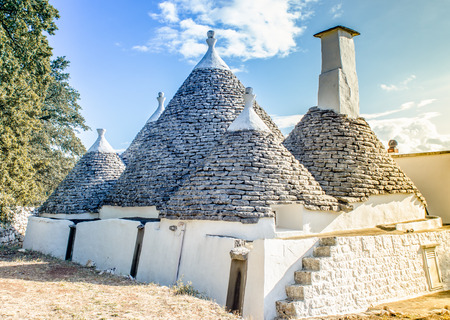 lanscape of a farm composed of ancient restored trulli currently used as homes for summer holidaysの写真素材