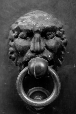 Close-up of an antique knocker on a dark background. Vertical viewの写真素材