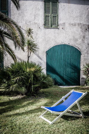 Detail of an old gate and windows in a farmhouse of the 800s, with a garden around and the shadows of the palms reflected. Retro styleの写真素材