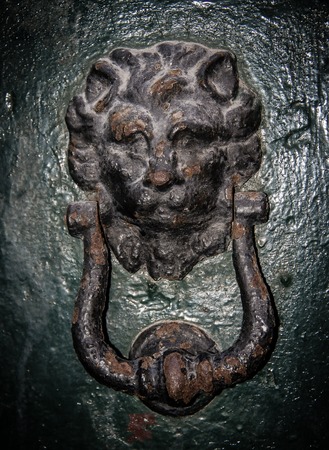 Close-up of an antique knocker on a dark background. Vertical viewの写真素材