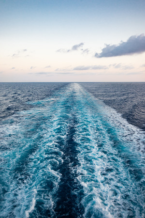 Scenic view of the sea from the stern of a luxurious cruise ship, against the sunrise on a beautiful blue sky. Vertical view.の写真素材