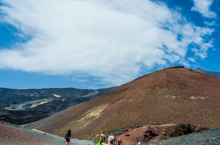 Volcano Etna, Catania, Sicily, Italy â 21 August 2014 : Tourists in front of the highest Etna volcano in Europe on a blue sky as a background. Horizontal view.のeditorial素材