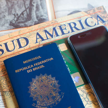 Milan, Italy â July 20, 2018 : A Brazilian passport and a smartphone over a tourist magazine of South America. Preparations for a trip to Latin America. Useful for travel agencies to advertise. Square viewのeditorial素材