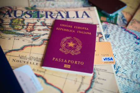 Milan, Italy â€“ July 20, 2018 : An Italian passport and a smartphone over a tourist magazine....