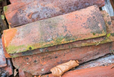 Ancient pieces of terracotta roof stacked. Old type of roof used in ancient times. Horizontal view.