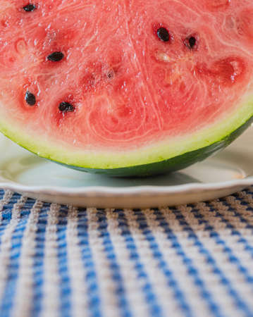 Fresh and clean cut watermelon with blurred background. Concept of freshness and summer time on the beach. Useful as a kitchen background.の写真素材