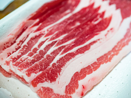 close-up of slices of raw bacon on a white tray. Used to create delicious dishes in the kitchen. Horizontal viewの写真素材