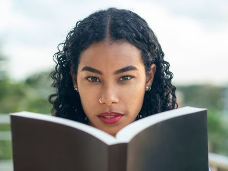 A college girl with Asian features is reading a book