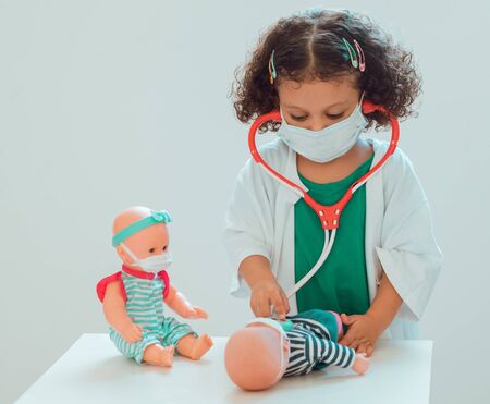 A little girl playing the doctor listens to the heart of her patient with a stethoscopeの写真素材
