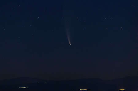 Comet C2020 F3 Neowise at night flies with its huge wake over various towns during its approach to our planet.の写真素材