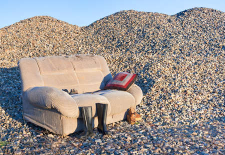 An abandoned sofa in a closed gravel pit that processed river stones.の写真素材
