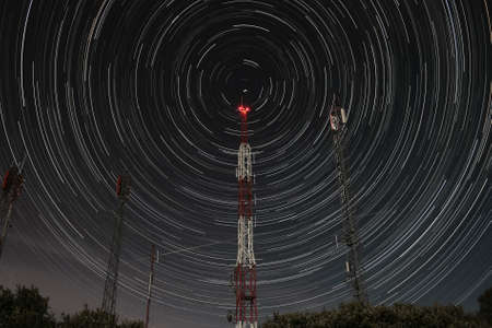 communication antennas on the mountain and circumpolar stars at night