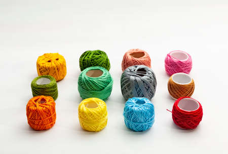 Set of several spools of thread of different colors on a white background.