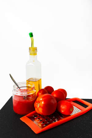 Preparing breakfast with oil and tomato juice with a metal graterの写真素材