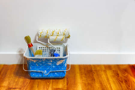 A putty knife, paint brush, sandpaper and wall sealing paste on a radiator ready to start renovating the walls. Indoors.の写真素材