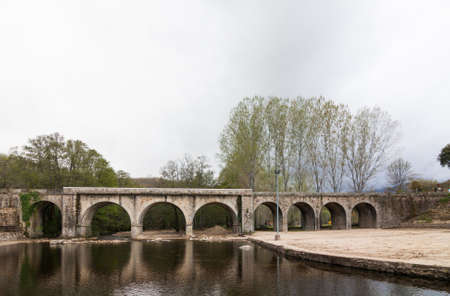 JARAIZ DE LA VERA, SPAIN - April 06, 2012: River with large water flow over a bridge in winter. The...