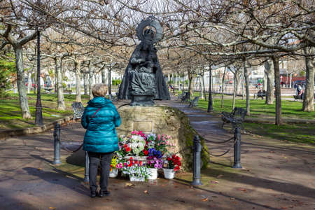 Plasencia, Caceres, Spain - January 24, 2021: A person prays before the sculpture of the Virgen del Puerto located in the Coronation Parkのeditorial素材