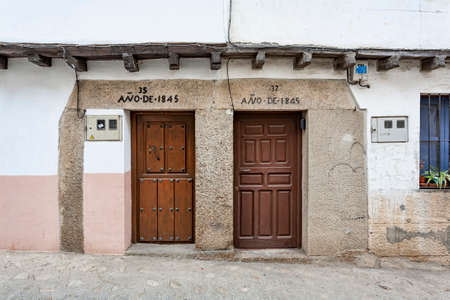 Villanueva de la Vera, Spain - March 08, 2021: View of two doors of neighboring houses built according to the inscription in the year 1845, example of the typical and traditional architecture of the townのeditorial素材