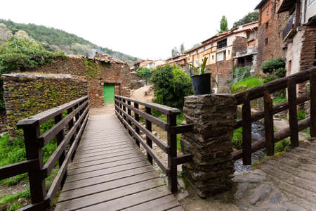 Robledillo de Gata, Spain - March 27, 2021: A wooden bridge to cross the Arrago river with a...