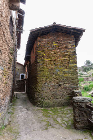 Robledillo de Gata, Spain - March 27, 2021: A house made of adobe and slates without windows and with a wooden roof and clay tiles.のeditorial素材