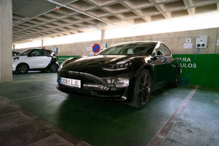 Plasencia, Spain - September 24, 2021: Charging a modern electric car in a public parking lot, they...