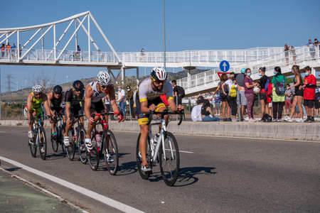 Fitness athletes pedaling their bikes during a national Triathlon, swimming, cycling and running events.のeditorial素材