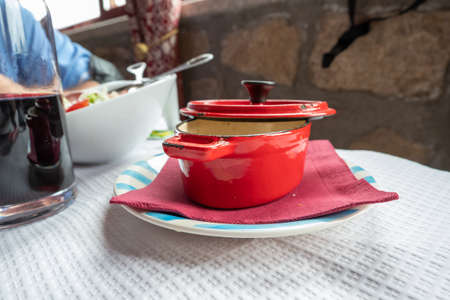 Casserole or metal saucepan of red porcelain used to present the brothの写真素材