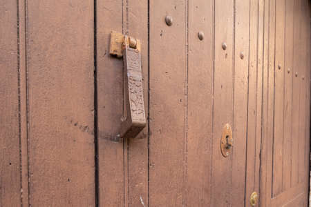 Old rusty iron door knocker with carved ornaments