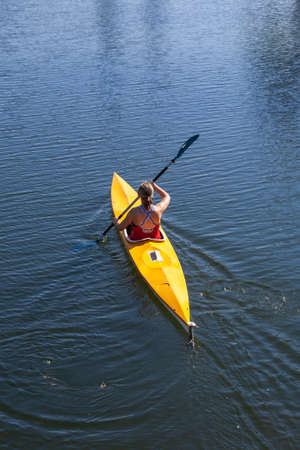 A young woman practices canoeing riding in his canoeのeditorial素材