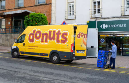 Yellow Donuts delivery van parked by the side of the road.のeditorial素材