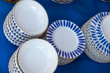 Collection of white and blue ceramic pottery, plates and cups are local craft products from Spain....