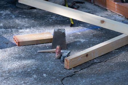 A trowel, some wooden boards and bricks on a construction site, building materials.
