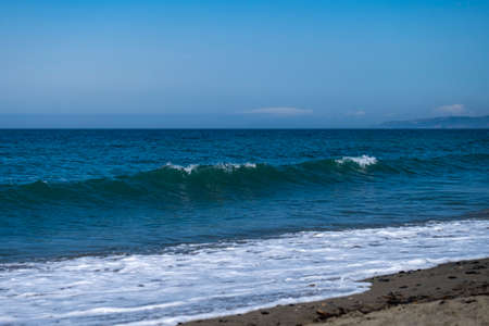 Ocean waves crashing on sandy beach. Sea waves breaking on shore. Sea waves breaking on Maditerranean's shoreの写真素材
