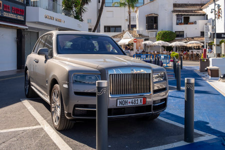 Estepona, Malaga, Spain - June 07, 2022: Luxury cars parked next to yachts in the marina of...