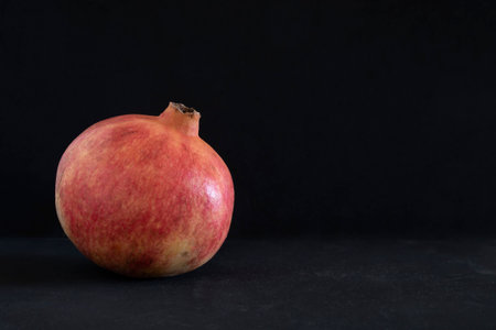 red big pomegranate on dark backgroundの写真素材