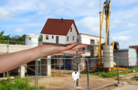 Hand holding a house with a bunch of keysの写真素材