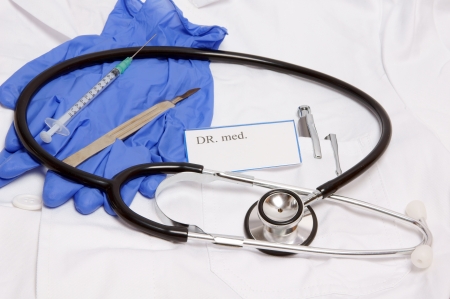 Lab coat with stethoscope and surgical utensilsの写真素材