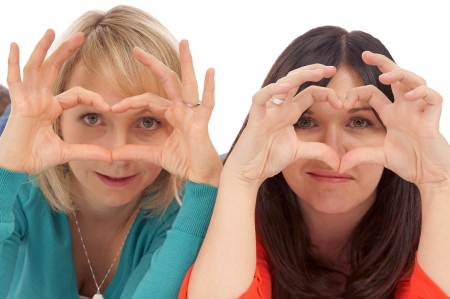 Two women making a heart with her handsの写真素材