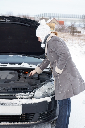 Car break - woman looks into the engine compartmentの写真素材