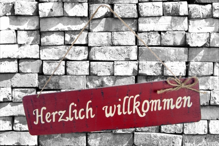 Sign on a stone wall and the german words cordially welcomeの写真素材