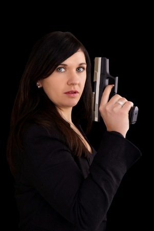 woman with handgun over a black backgroundの写真素材