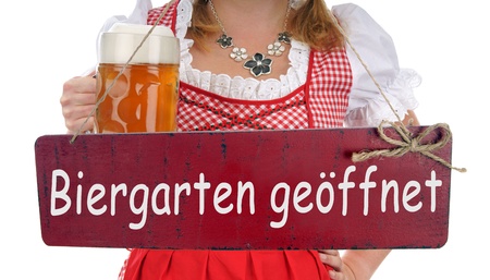 pretty woman with a beer mug and sign with the german words beer garden openの写真素材