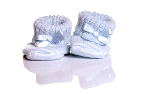 little baby shoes over a reflective backgroundの写真素材