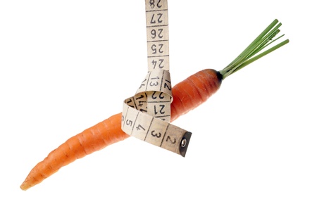 Carrots with tape measure isolated over a white backgroundの写真素材