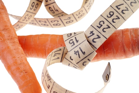 carrots with measure tape over a white backgroundの写真素材