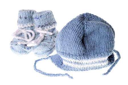 knitted baby shoes and knitted hat isolated over a white background